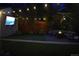 Cozy backyard at night featuring a fire pit, patio seating, an outdoor tv, and decorative string lights at 3055 S Bannock St, Englewood, CO 80110