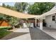 Gravel backyard area with stone pavers, a shade sail, outdoor kitchen, and additional seating at 3055 S Bannock St, Englewood, CO 80110