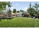 Large backyard with a well-maintained lawn and an entertainment area with a fire pit, patio, and shade sails at 3055 S Bannock St, Englewood, CO 80110