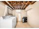 Unfinished basement with a laundry area, including a washer and dryer, plus exposed ceilings at 3055 S Bannock St, Englewood, CO 80110