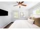 Bright bedroom features a ceiling fan, large windows, and hardwood floors at 3055 S Bannock St, Englewood, CO 80110