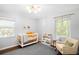 Bright Bedroom featuring a crib, bookshelf, chair, and two windows at 3055 S Bannock St, Englewood, CO 80110