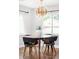 Bright dining room features an eye-catching modern chandelier, warm wood floors, and light gray walls at 3055 S Bannock St, Englewood, CO 80110
