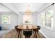 Bright dining room features an eye-catching modern chandelier, warm wood floors, and light gray walls at 3055 S Bannock St, Englewood, CO 80110
