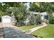 Charming home exterior with a walkway leading to the front door, fresh landscaping, and a detached garage at 3055 S Bannock St, Englewood, CO 80110