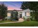 Twilight exterior view of a charming home with mature trees and landscaping at 3055 S Bannock St, Englewood, CO 80110