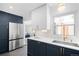 Bright kitchen features stainless steel appliances, white countertops, navy cabinets, and gold hardware at 3055 S Bannock St, Englewood, CO 80110