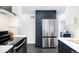 Bright kitchen features stainless steel refrigerator, white countertops, and navy blue cabinets with gold hardware at 3055 S Bannock St, Englewood, CO 80110