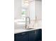 Bright kitchen features stainless steel faucet, white countertops, navy cabinets, and gold hardware at 3055 S Bannock St, Englewood, CO 80110