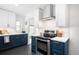 Modern kitchen features stainless appliances, white backsplash, white countertops, and navy blue cabinets at 3055 S Bannock St, Englewood, CO 80110