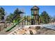 Community playground with a tower, multiple slides, rock climbing walls, and green artificial turf at 3055 S Bannock St, Englewood, CO 80110