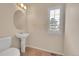 Powder room with pedestal sink, decorative mirror, and tiled floors, illuminated by natural light from the window at 4042 E Hinsdale Cir, Centennial, CO 80122