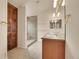 Bright bathroom featuring a double vanity, glass enclosed shower, and built-in storage cabinet at 4042 E Hinsdale Cir, Centennial, CO 80122