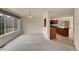 Sunlit living room flows into kitchen with dark cabinets and an island, plus large windows providing scenic views at 4042 E Hinsdale Cir, Centennial, CO 80122