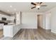 Open-concept living area with modern light fixtures and wood-look flooring, seamlessly flowing into the kitchen at 48215 Shetland Dr, Bennett, CO 80102