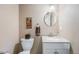 Powder room featuring a round mirror, speckled countertop, and framed artwork at 5224 Snow Goose St, Brighton, CO 80601