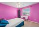 Bright bedroom features pink walls, natural light, and a stylish white desk, creating a vibrant space at 5224 Snow Goose St, Brighton, CO 80601