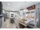 Open kitchen with island, white cabinets, access to deck via sliding glass doors, and eat-in kitchen space at 5224 Snow Goose St, Brighton, CO 80601