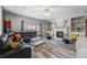 Open living area featuring a fireplace, built-ins, hardwood floors, and a large black sectional at 5224 Snow Goose St, Brighton, CO 80601