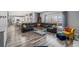 A spacious living room featuring a large leather sectional, wood floors, and an open view to the kitchen area at 5224 Snow Goose St, Brighton, CO 80601