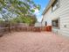 Home's gravel-covered backyard features a wooden fence and a small shed under a sunny blue sky at 1460 Belmont Dr, Longmont, CO 80503
