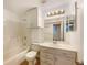 Bright bathroom features a bathtub, toilet, single sink vanity with storage, and a large mirror at 1460 Belmont Dr, Longmont, CO 80503