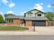 Charming two-story home with brick facade, dormer windows, well-manicured lawn and two car garage at 1460 Belmont Dr, Longmont, CO 80503