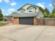 View of home's gray two-car garage and long concrete driveway, under a sunny sky with fluffy clouds at 1460 Belmont Dr, Longmont, CO 80503