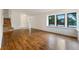 Open-concept living room with wood floors, stairs, and a large window offering a sunny view at 1460 Belmont Dr, Longmont, CO 80503