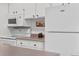 Bright kitchen features white appliances and cabinetry at 7375 E Quincy Ave # 204, Denver, CO 80237