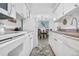 Galley kitchen featuring white cabinetry and laminate countertops, adjacent to dining area at 7375 E Quincy Ave # 204, Denver, CO 80237