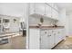 Bright kitchen with white cabinets and stainless steel sink, adjacent to the living area at 7375 E Quincy Ave # 204, Denver, CO 80237