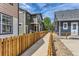 The backyard features a walkway between two neighboring homes and a wooden fence at 511 Noel Ave, Longmont, CO 80501