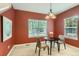 Cozy dining area with modern chandelier, warm red walls, and natural light at 511 Noel Ave, Longmont, CO 80501