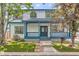 Charming two-story home with a covered front porch and beautiful blue accents on the trim and railings at 511 Noel Ave, Longmont, CO 80501