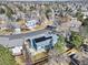 Aerial view of a blue home featuring solar panels, surrounded by mature trees, and residential streets at 15592 E Kenyon Ave, Aurora, CO 80013