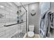 Modern bathroom featuring a glass enclosed shower with hexagon tiles, toilet, and gray accent wall at 15592 E Kenyon Ave, Aurora, CO 80013