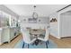 Elegant dining room with a round table, stylish chairs, and modern chandelier over a blue rug at 15592 E Kenyon Ave, Aurora, CO 80013
