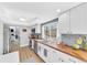 Modern, white kitchen with stainless appliances, wood countertops, and a beautiful garden view at 15592 E Kenyon Ave, Aurora, CO 80013