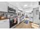 Modern kitchen with stainless steel appliances, white cabinets, and a bright, open layout at 15592 E Kenyon Ave, Aurora, CO 80013