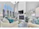 Bright living room with a cozy fireplace, a large TV, soaring ceilings, and oversized windows at 15592 E Kenyon Ave, Aurora, CO 80013