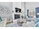 Comfortable living room featuring a fireplace, large TV, stylish decor, and modern furniture at 15592 E Kenyon Ave, Aurora, CO 80013