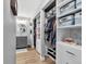 Organized walk-in closet boasting built-in shelving, hanging rods, drawers, and convenient access to the sink at 15592 E Kenyon Ave, Aurora, CO 80013