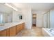 Bright bathroom featuring double sinks, a glass enclosed shower, and a soaking tub at 15577 Greenstone Cir, Parker, CO 80134