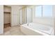 Bright bathroom featuring a large soaking tub and a glass enclosed shower at 15577 Greenstone Cir, Parker, CO 80134