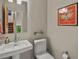 Bright bathroom featuring a white sink, toilet, and colorful artwork adorning the wall at 1880 W 32Nd Ave, Denver, CO 80211