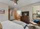 Bedroom with a large TV on dresser, cozy chair, and open doorway to the bathroom at 1880 W 32Nd Ave, Denver, CO 80211