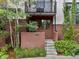 Inviting townhouse entrance featuring a small balcony, lush landscaping, and a well-maintained exterior at 1880 W 32Nd Ave, Denver, CO 80211