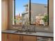 Close-up of kitchen sink area with modern faucet, stylish backsplash, and a view of the neighborhood at 1880 W 32Nd Ave, Denver, CO 80211