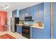 Retro kitchen featuring blue cabinets with black appliances and a tile floor at 3131 E Alameda Ave # 2102, Denver, CO 80209